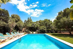 A rectangular swimming pool with a clear blue water surface, surrounded by a grassy area and trees. - Finca Puna with pool, quiet location, A/C, Wifi, 7 km to the beach (IB)