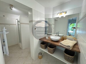 Tina con regadera, secadora de cabello, bidet, toallas 