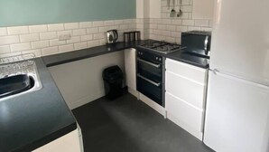 Una cocina con estufa, horno y refrigerador.