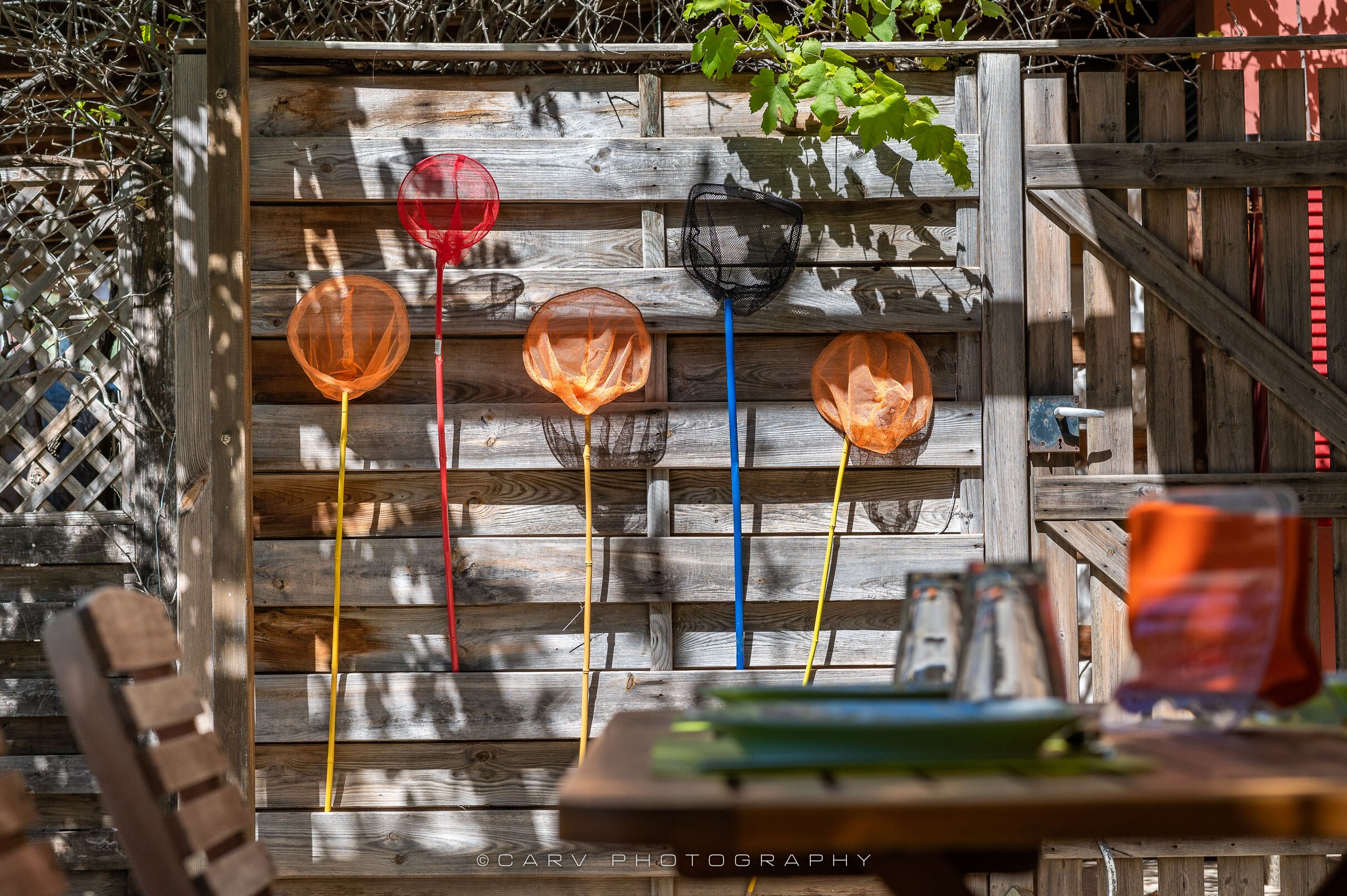 A wooden fence with colorful plastic items attached to it.