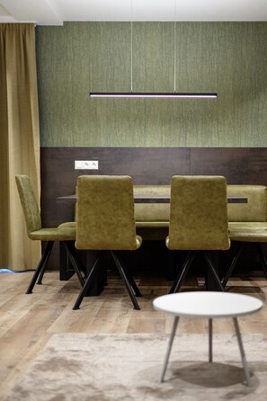 Conference room with a long table and four chairs, surrounded by a textured panel and ceiling-mounted lighting.