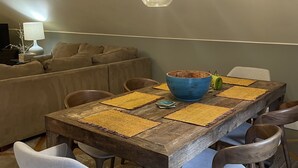 Een eetgedeelte met een houten tafel, zes stoelen en een blauwe kom.
