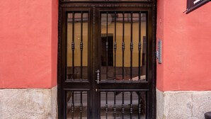 A building entrance with a black door, a sign reading "limelhome 36", and a tiled pavement. - Limehome Madrid C. de Fomento (Madrid)