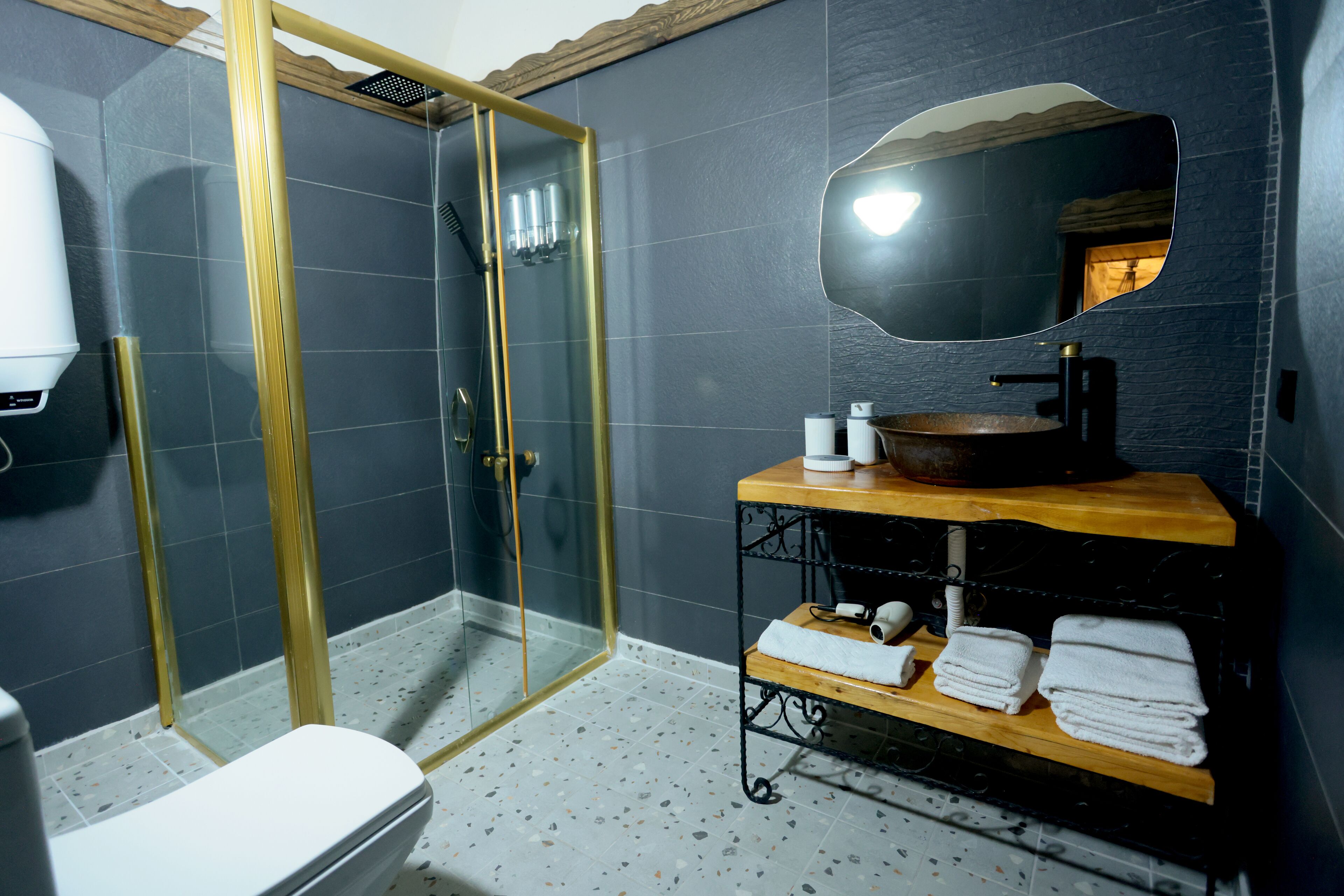 A bathroom with a glass-enclosed shower, a sink with a wooden vanity, and a mirror above the sink.