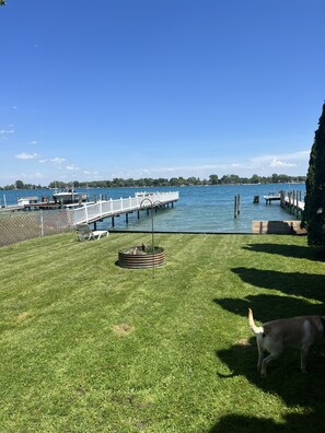 Enjoy a serene backyard retreat with a dock, lawn, and seating area.