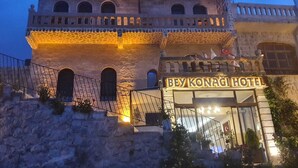 A stone building with a balcony and a sign that reads "BEY KONAGI HOTEL".