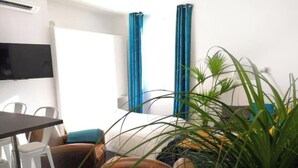 Een moderne hotelkamer met een bed, een bureau, een stoel en een kamerplant.