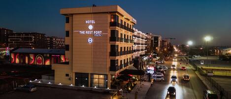 A hotel with a sign reading "The Rest Port" and a visible entrance with a covered area.
