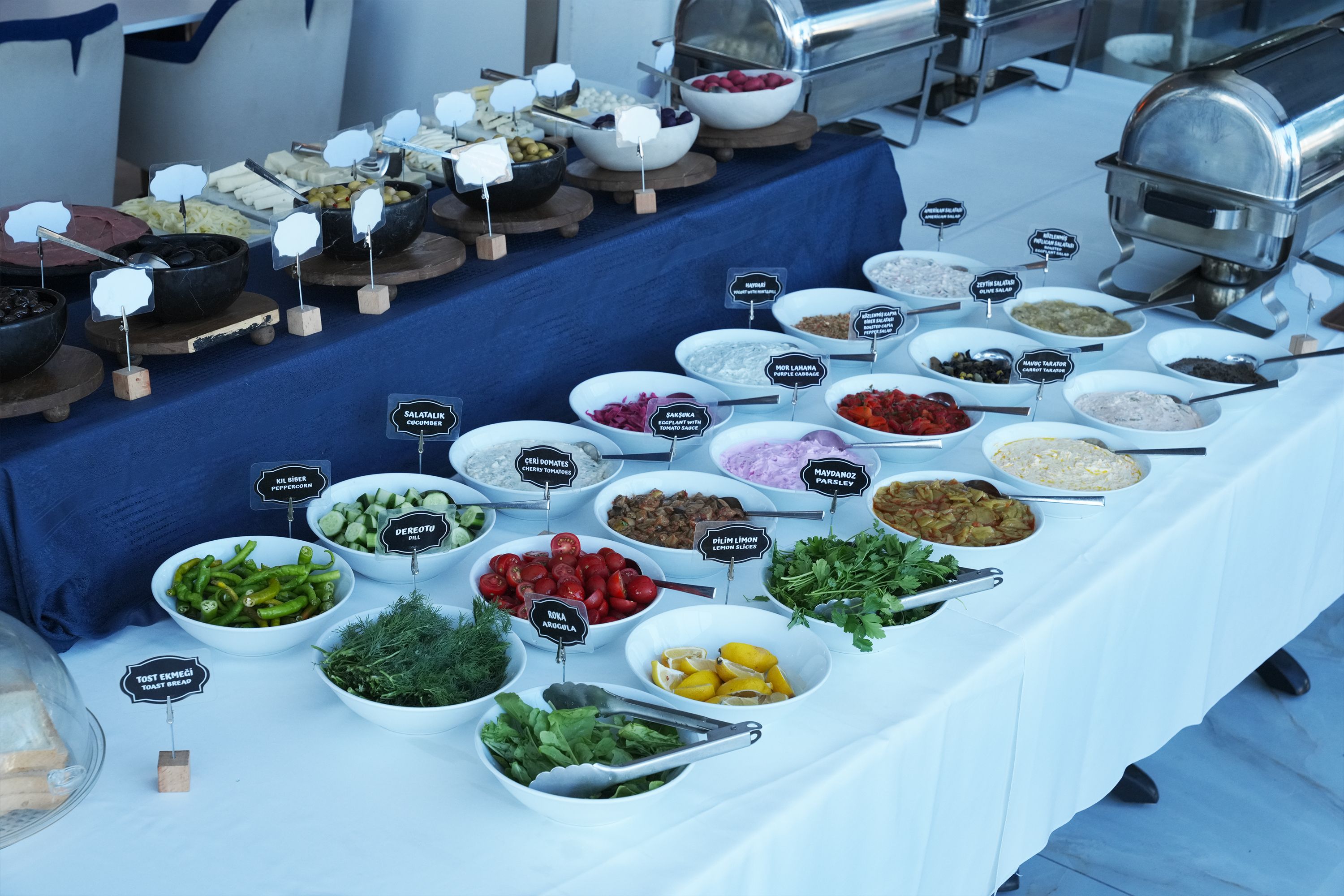 A buffet table with various food items and condiments.