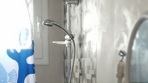 A bathroom with a shower, a sink, and a mirror.