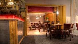 Een hotellobby met een receptiebalie, een zithoek en een eetgedeelte.