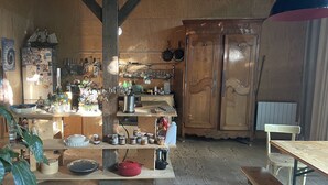 Eine rustikale Küche mit Holzschränken, einem Holztisch und einer Bank.