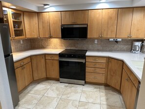 Enjoy cooking in this kitchen with a stove, oven, microwave, coffee maker, and sink.