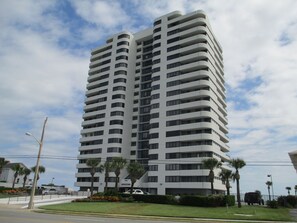 Stylish high-rise building with balconies and lush landscaping.