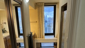 Un pasillo con un banco, un ventanal con vistas y una puerta.