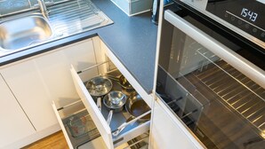 Eine Küche mit Spüle aus Edelstahl, einer Mikrowelle und einem Backofen.