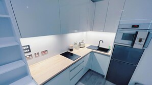 A modern kitchen with a built-in oven, a sink, and a toaster. - Modern Studio Apartment Gibraltar (Gibraltar)