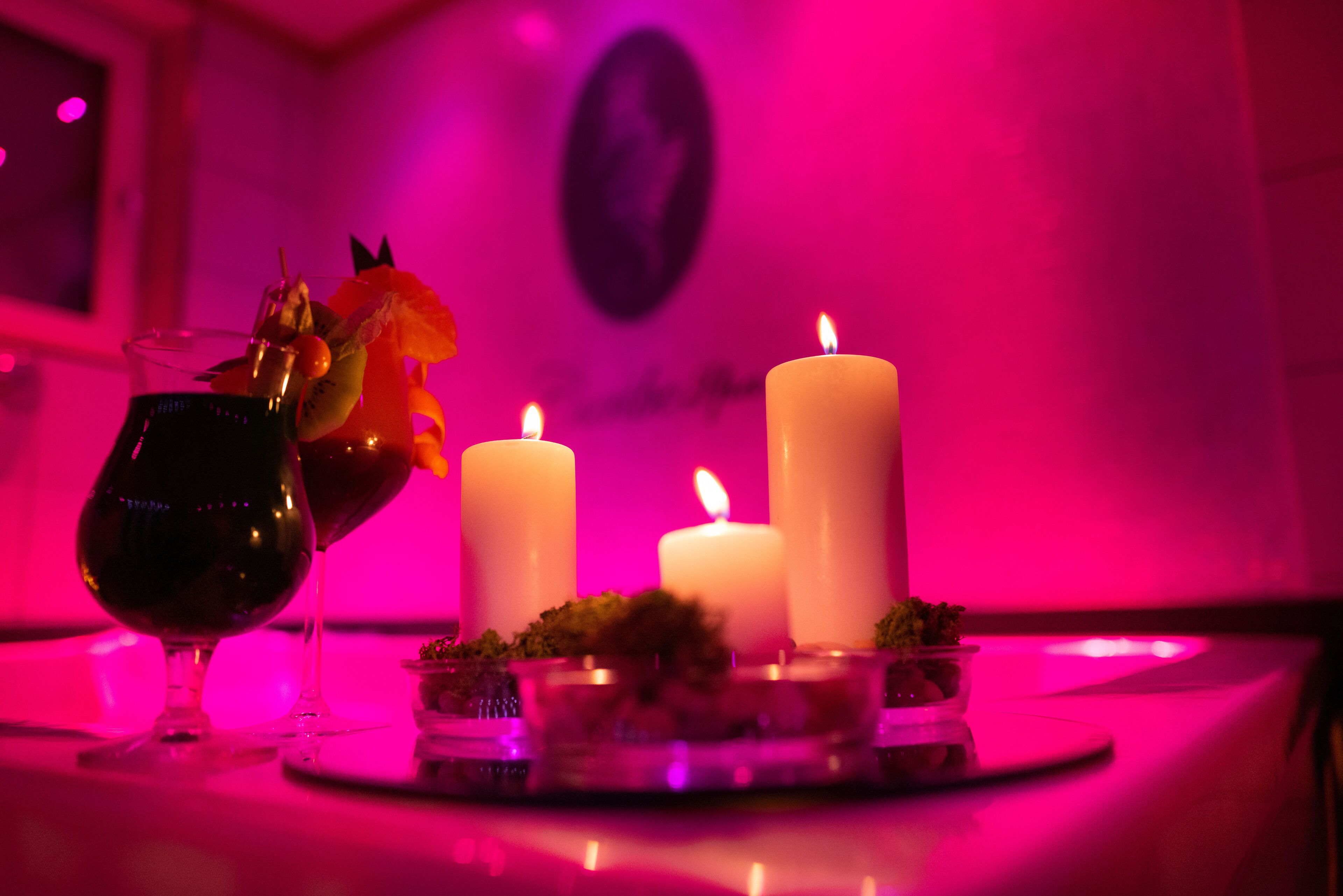 A table with candles and a glass of wine.