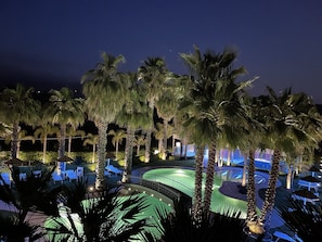 A nighttime view of a resort with palm trees, a pool, and lounge chairs. - Villa Caribe Resort & Spa - Adult Recommended (Spigno Saturnia)