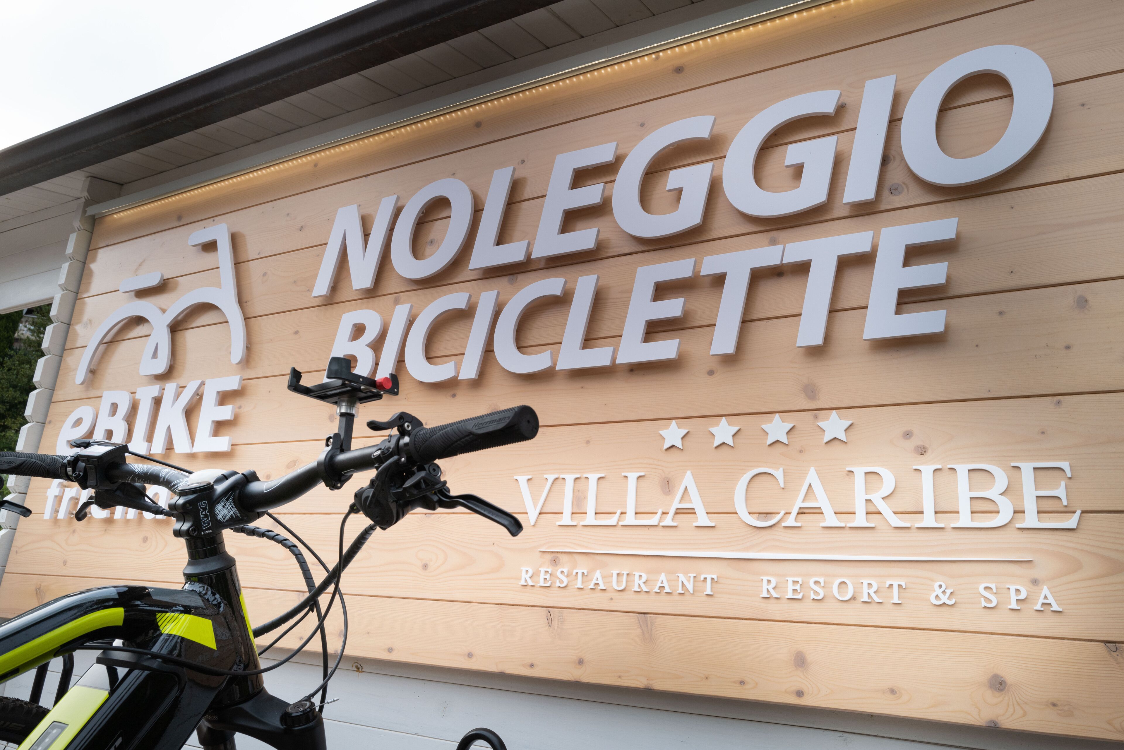 En träskylt som visar var man kan hyra cyklar och en restaurang som heter Villa Caribe.