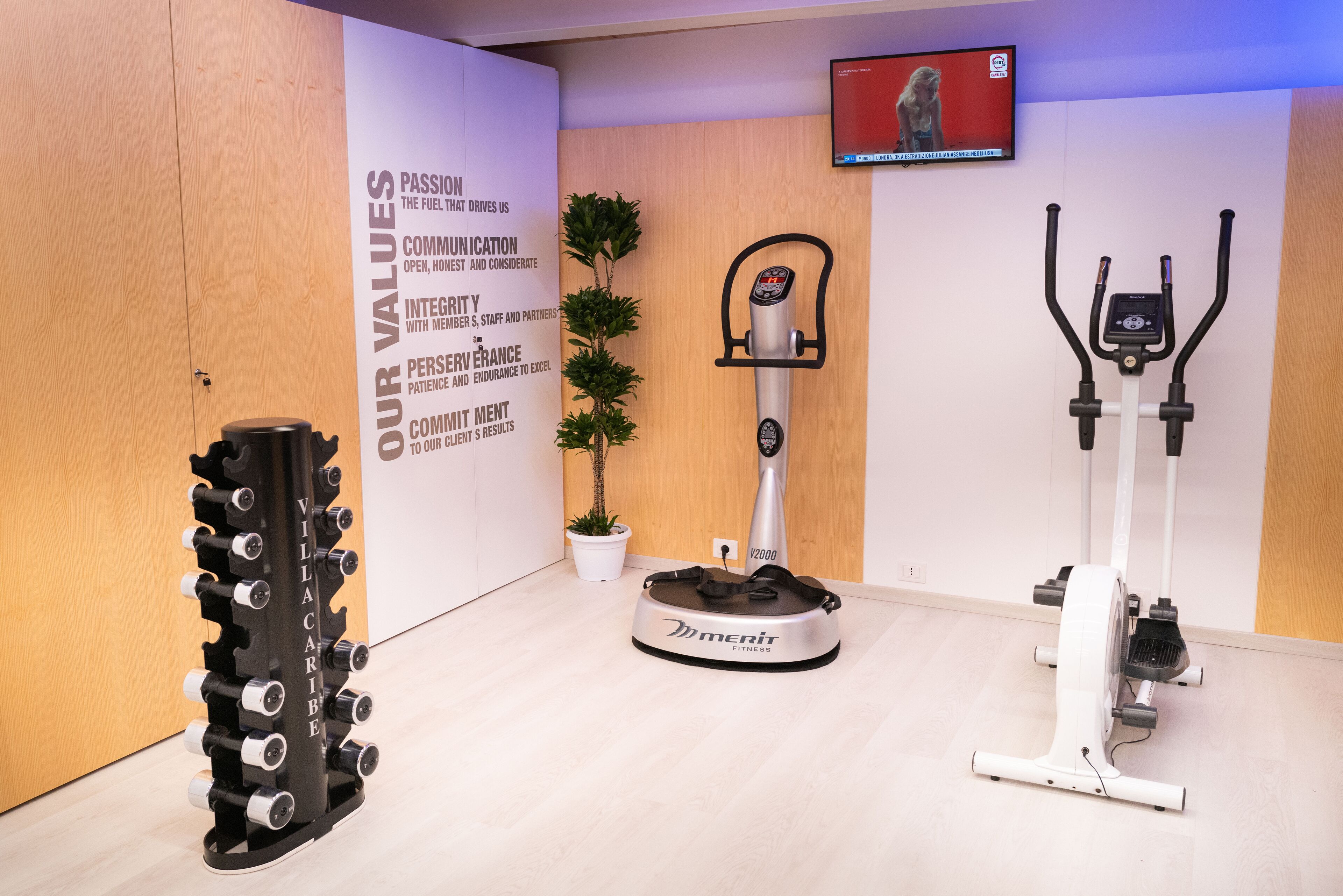 A fitness area with a rowing machine, an elliptical trainer, and a stationary bike.