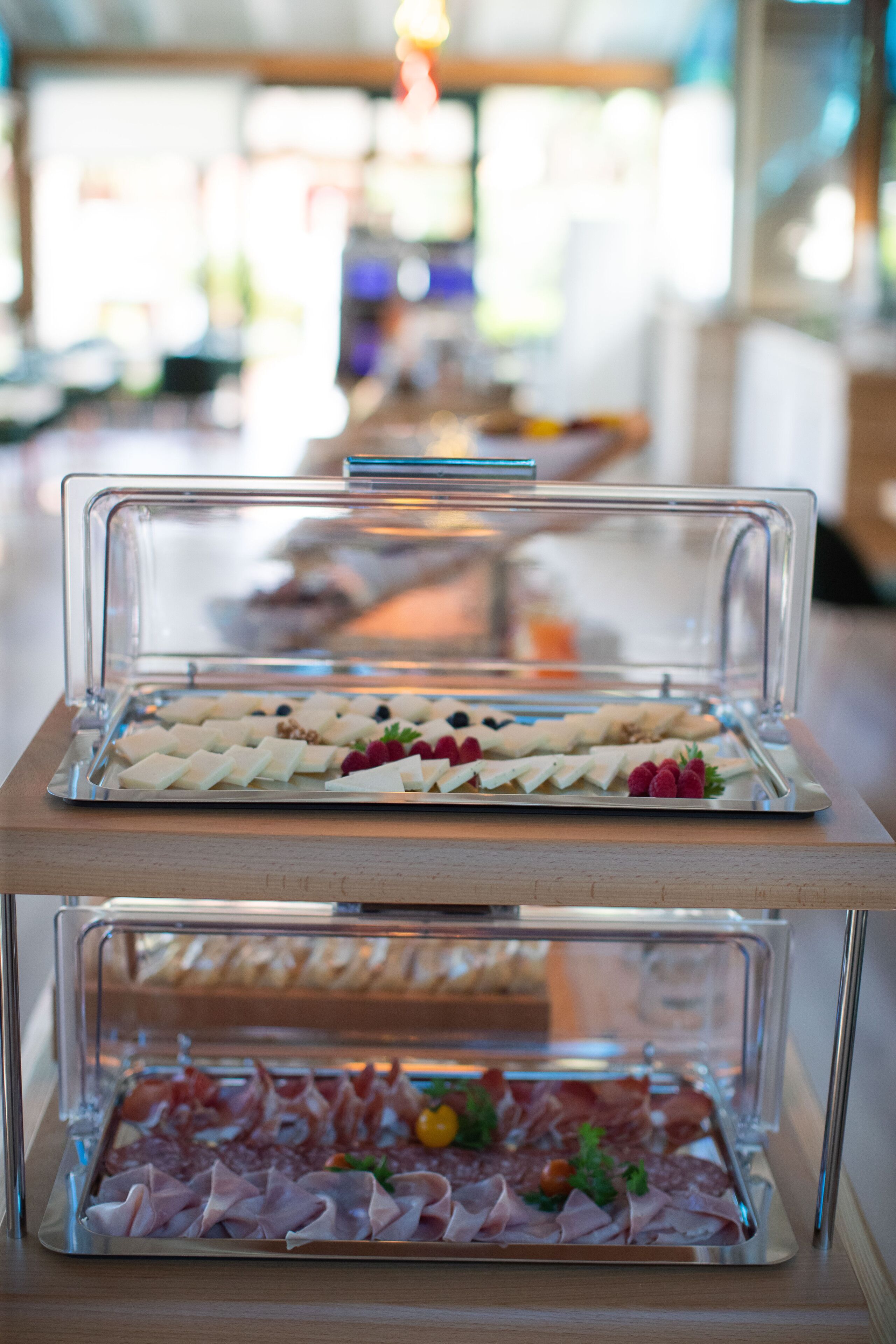 Un buffet avec différents plats présentés dans des plateaux transparents.