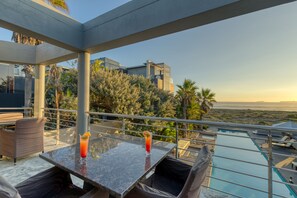 Une terrasse sur le toit avec une piscine, un espace salon et une vue sur le paysage.