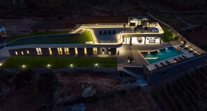 A modern house with a swimming pool, a covered patio, and a well-lit exterior. - Luxury Villa Madre with heated Mineral pool, Whirlpool, Outdoor Gym (Zmijavci)