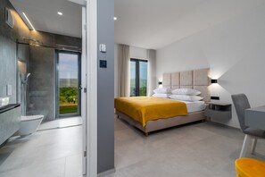 A modern hotel room with a large bed, a desk, and a bathroom. - Luxury Villa Madre with heated Mineral pool, Whirlpool, Outdoor Gym (Zmijavci)