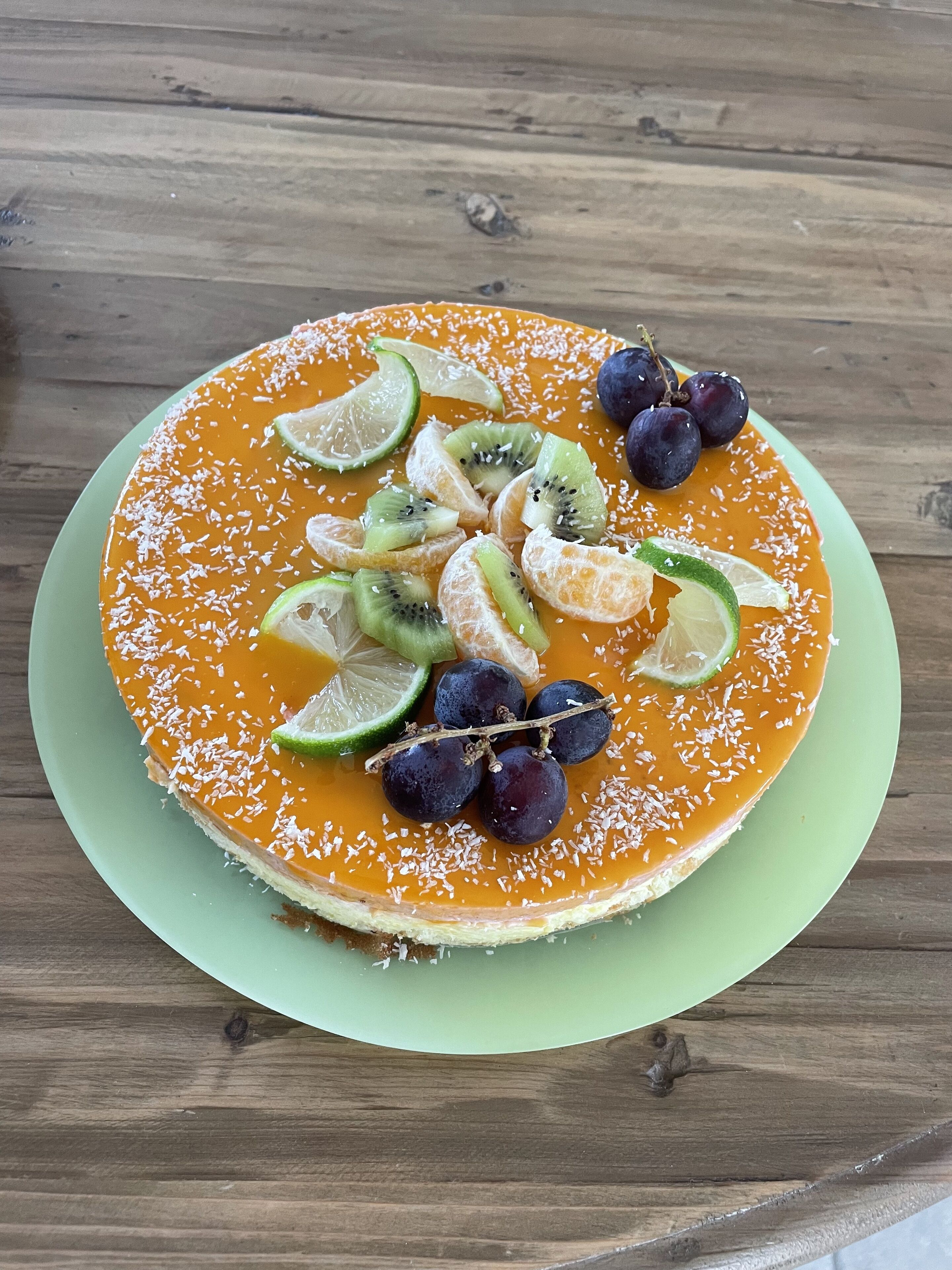 Ein Dessert auf einem grünen Teller vor einem Holztisch.