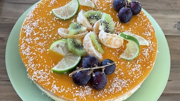Ein Dessert auf einem grünen Teller vor einem Holztisch.