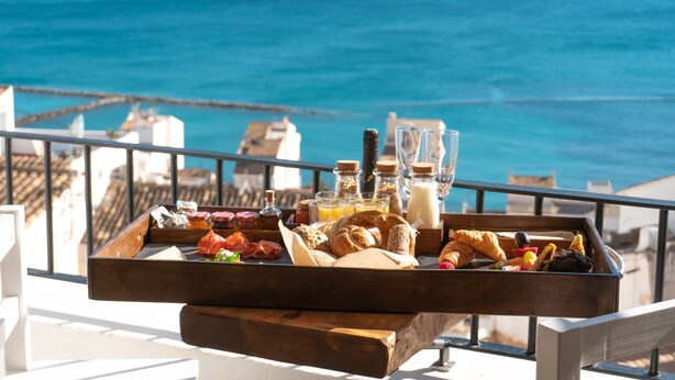 A breakfast tray with pastries, fruits, and beverages on a balcony overlooking the sea. - Porta Nova Suites Altea - Adults Only (Altea)