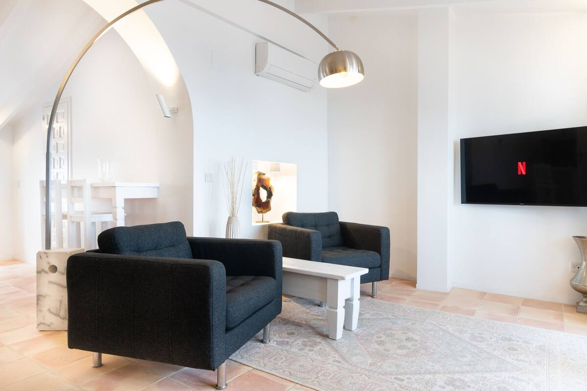A modern living room with a sofa set, a coffee table, and a TV mounted on the wall.
