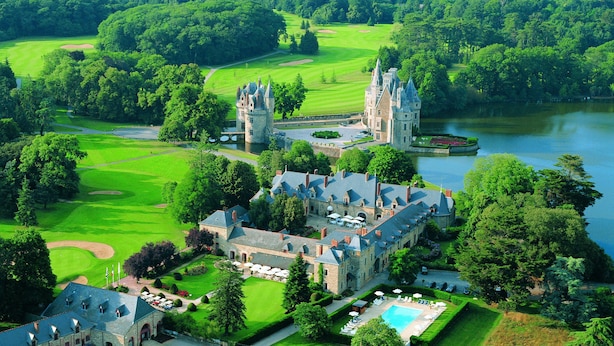 Een kasteel met een ruime binnenplaats, een zwembad en een golfbaan.