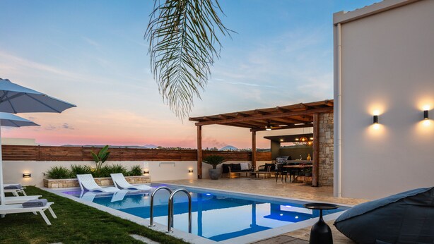 Un espace piscine extérieur moderne, doté de chaises longues, d’une pergola et d’un bar.