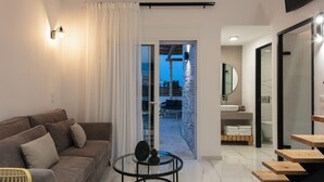 Un salon moderne avec un canapé, une table basse en verre et une vue sur un espace extérieur grâce à une porte-fenêtre coulissante.