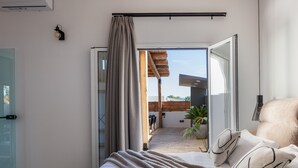 Une chambre avec un lit, une vue sur le patio extérieur, une porte-fenêtre coulissante et un ventilateur de plafond.