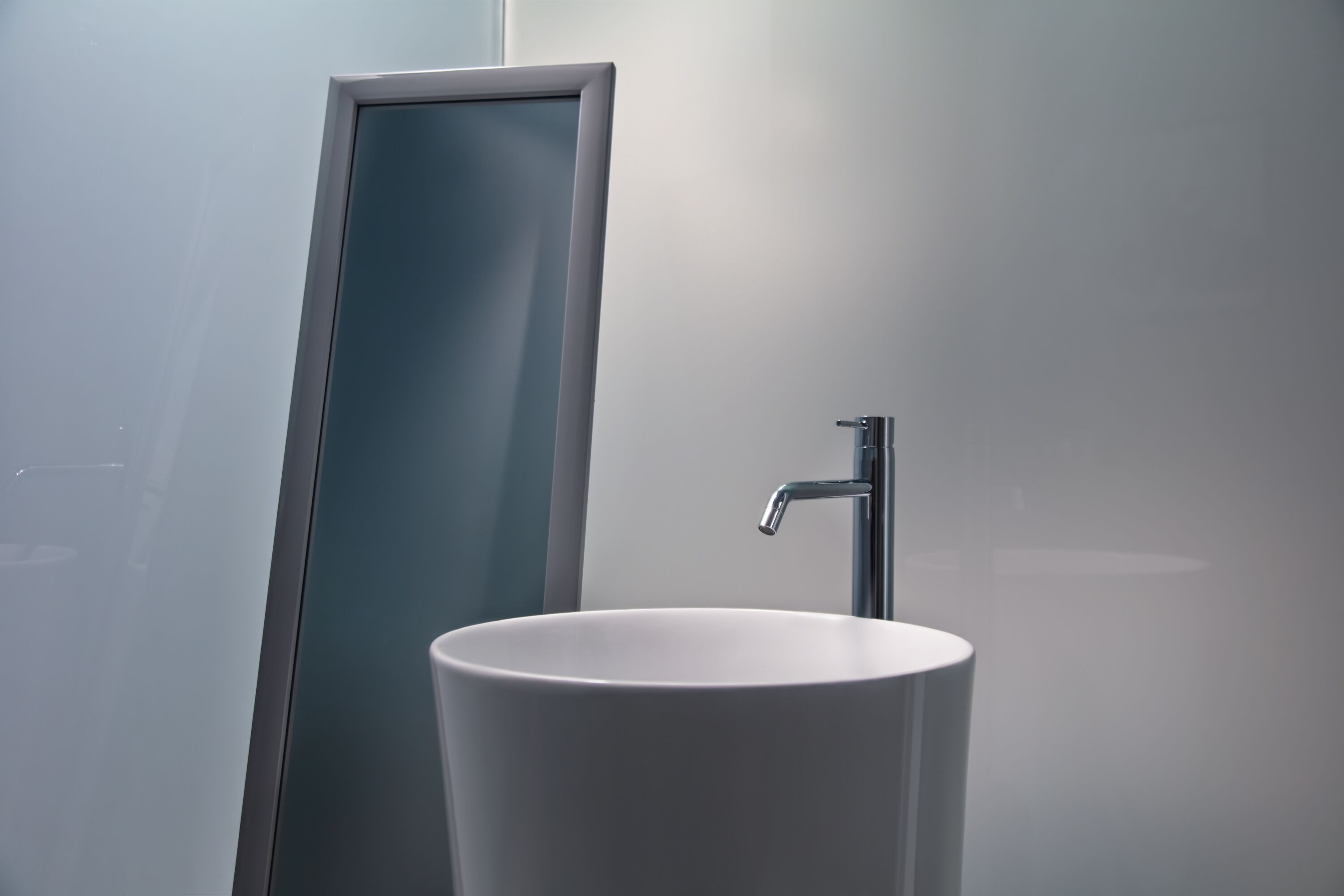 Un baño con un lavamanos blanco y un espejo.