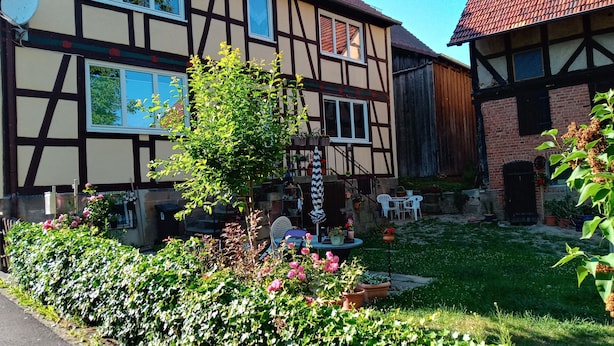 A traditional half-timbered house with a garden in front.
