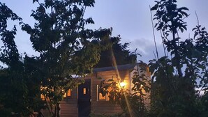 A wooden cabin with a front door, windows, and a small porch. - Luxury romantic shepherd's hut - hot tub and Aga  (Camelford)