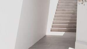 A modern, minimalist staircase in a white-walled corridor. - Pnoes Tinos  (Tinos)