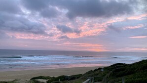 A beach with waves and a cloudy sky.