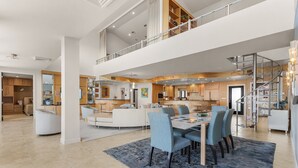 A spacious, modern interior with a dining area, kitchen, and a mezzanine level. - Penthouse on the Beach! Beautiful Sunset Views! (Fort Myers)