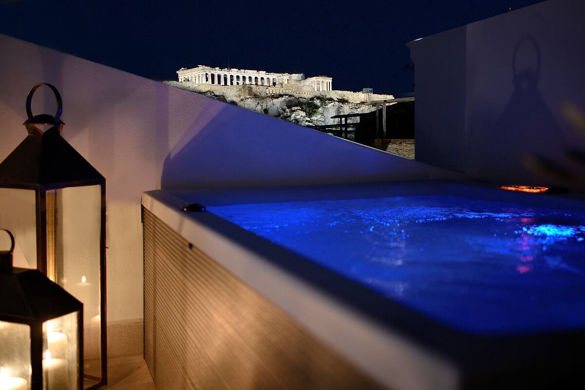 Une terrasse sur le toit avec un jacuzzi, une lanterne et une vue sur un bâtiment historique.