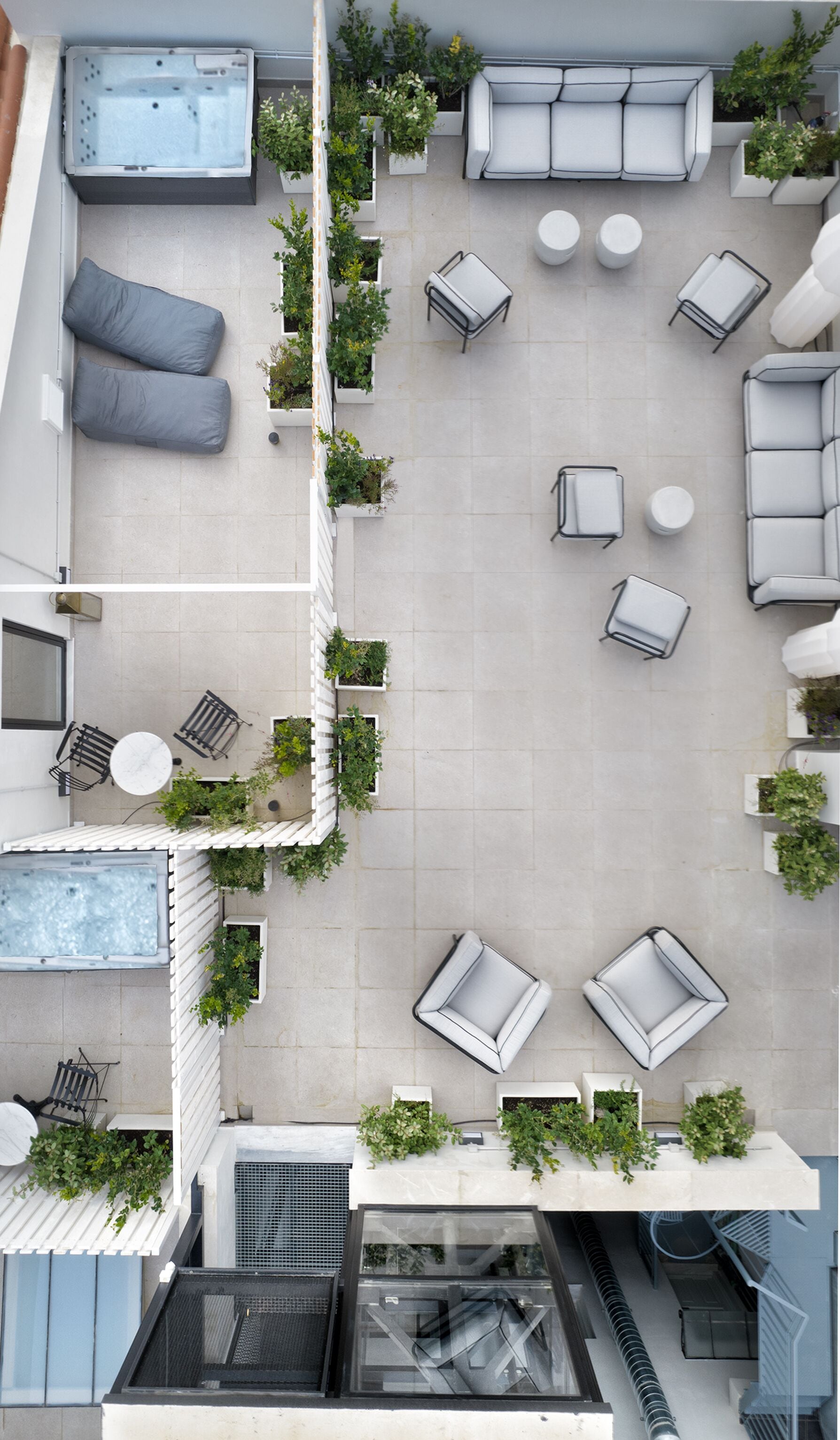 A rooftop terrace with a hot tub, multiple seating areas, and potted plants.