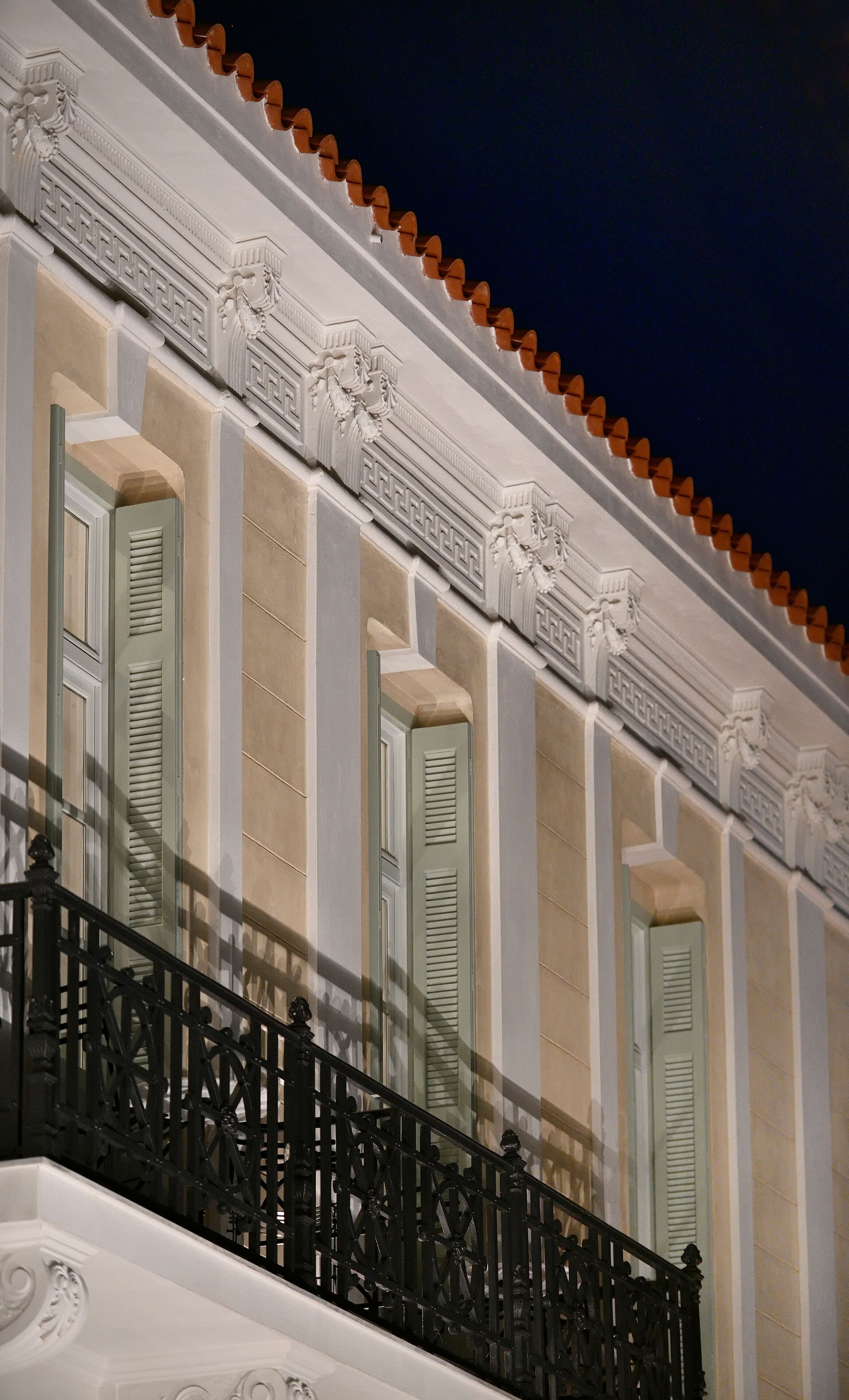 Fachada de edificio con detalles arquitectónicos clásicos, incluyendo columnas y molduras decorativas.