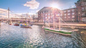 A canal with boats, a bridge, and a building with an American flag. - Gorgeous apt, pets, hot tub & fire pit, walk --> DT Frederick (Frederick)