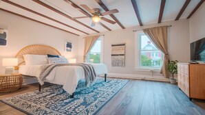 A bedroom with a bed, a ceiling fan, a window, and a television. - Gorgeous apt, pets, hot tub & fire pit, walk --> DT Frederick (Frederick)