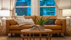 A cozy living room with a brown sofa, a round coffee table, and a potted plant. - Gorgeous apt, pets, hot tub & fire pit, walk --> DT Frederick (Frederick)