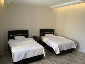 A hotel room with two single beds, each with a wooden headboard and white bedding. - Atlihan Plus Hotel (Dogubayazit)